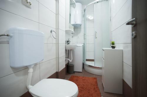 uma casa de banho branca com um WC e um lavatório em Apartman Leona em Kaštela