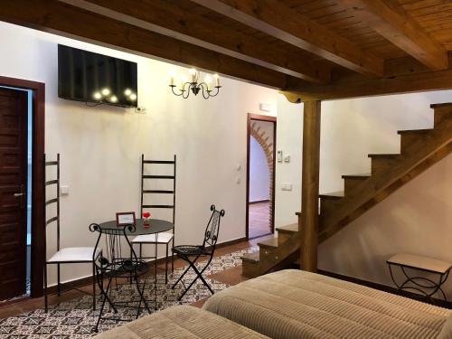 a bedroom with a bed and a table and a staircase at Retiro del Teatro Almagro in Almagro