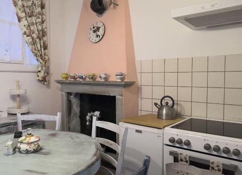 a kitchen with a stove and a table with a tea kettle at Casa Angiolina - Holidays - Appartamento Dolce Letargo in Morcote