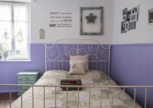 a bedroom with a bed with purple walls at Casa Angiolina - Holidays - Appartamento Dolce Letargo in Morcote