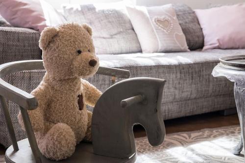 un osito de peluche sentado en una silla en una sala de estar en Casa Angiolina - Holidays - Appartamento Dolce Letargo, en Morcote