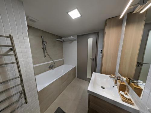 y baño con bañera, lavamanos y ducha. en AP10 - Apartments 4U Březinova "Overnight Simply", en Hradec Králové
