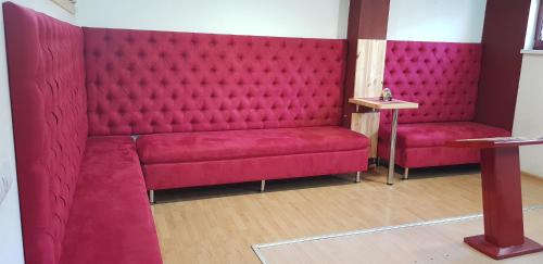 a red couch in a room with a table at Davi Penzion & Bowling in Rožňava