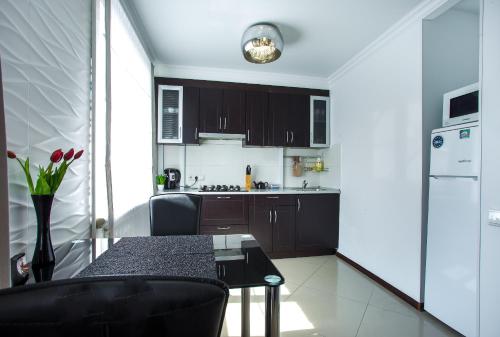 a kitchen with black cabinets and a table in a room at Lotos for You Apartments in Mykolaiv