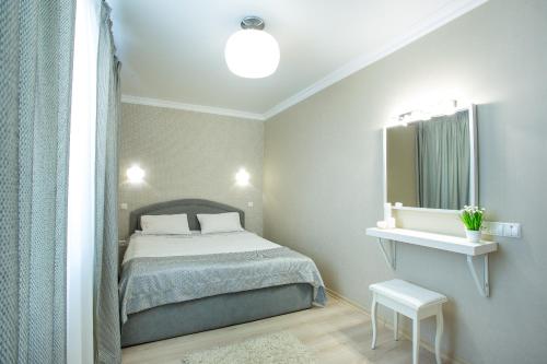a small bedroom with a bed and a mirror at Lotos for You Apartments in Mykolaiv