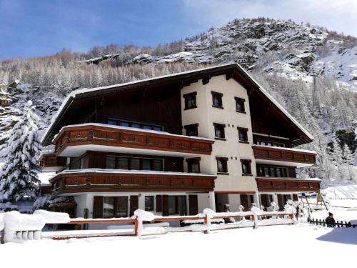 a large building in the snow with a mountain at Sunshine in Saas-Grund