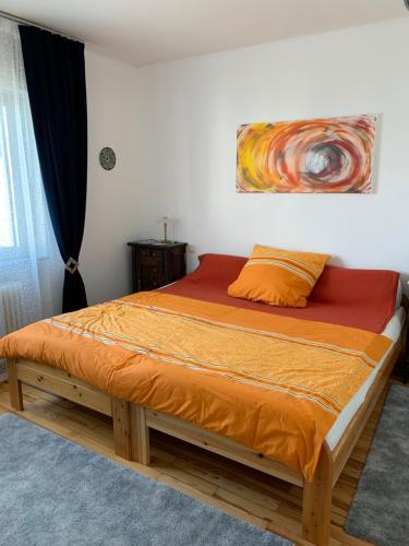 1 cama en un dormitorio con una pintura en la pared en Moderne Ferienwohnung mit Balkon im schönen Saarland, en Pachten