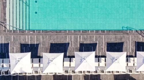 a group of white chairs on the side of a building at Ura Lara Adults Only in Puerto Rico de Gran Canaria