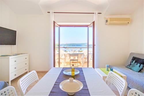uma sala de estar com uma mesa de jantar e vista para o oceano em Dream View Medulin em Medulin