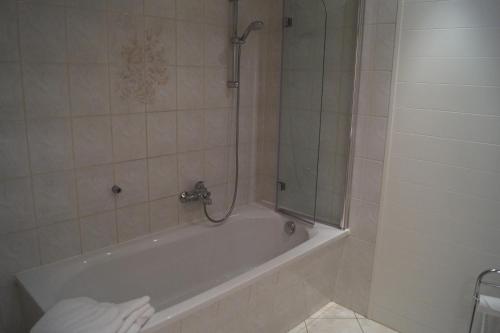a bathroom with a bath tub with a shower at Ferienwohnung Buschbeck in Marienberg