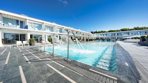 a swimming pool with a fountain in front of a building at Ura Lara Adults Only in Puerto Rico de Gran Canaria