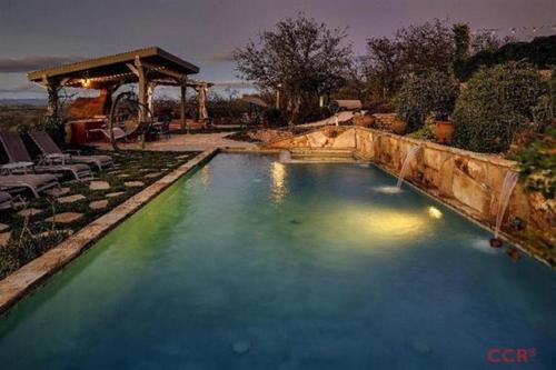 een zwembad met blauw water en een prieel bij High Ridge Manor in Paso Robles