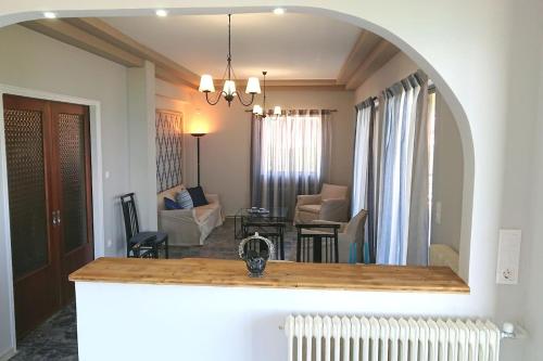 a living room with an archway over a kitchen counter at patra's sea front apartment in Flámbouras