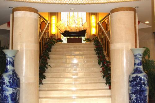 a staircase with two blue and white vases at Soluxe Hotel Almaty in Almaty