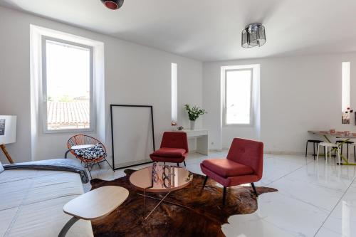 a living room with two red chairs and a table at Alpinias Bed and Breakfast in Marseille