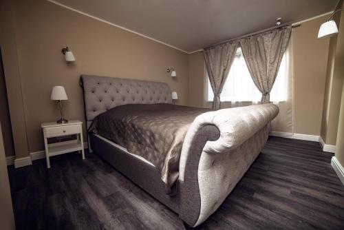 a bedroom with a large bed and a window at Royal Sauna Apartments in Klaipėda