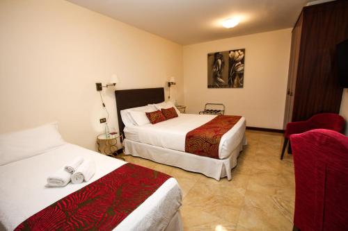 a hotel room with two beds and a chair at Il Sogno di Gio de la Laguna in La Laguna
