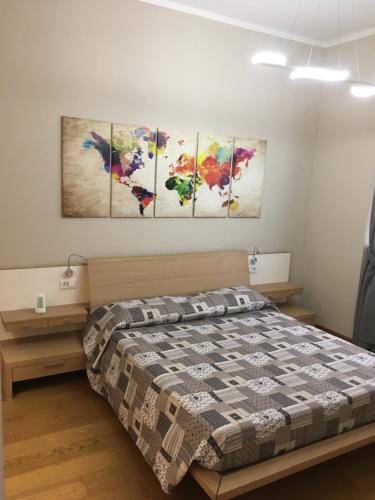 ein Schlafzimmer mit einem Bett und vier Gemälden an der Wand in der Unterkunft Cooper Apartment in Genua