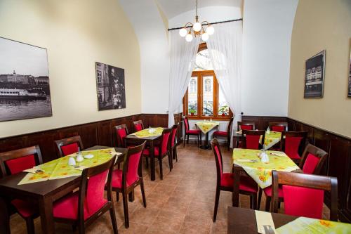 a dining room with tables and red chairs at Hotel Petr in Prague