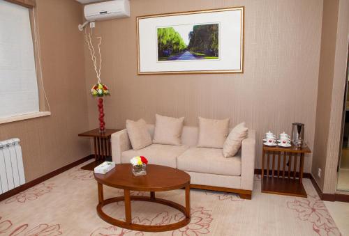 a living room with a couch and a table at Soluxe Hotel Almaty in Almaty