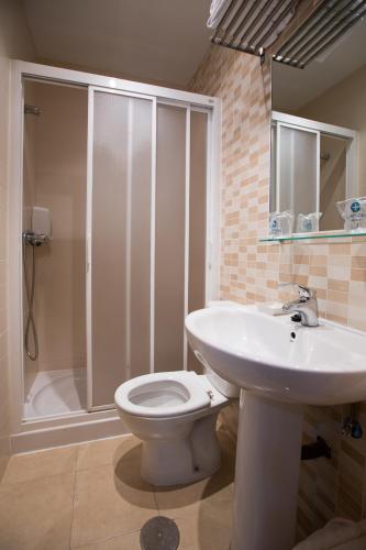 a bathroom with a sink and a toilet and a shower at Hostal Gaudi Cuenca in Cuenca