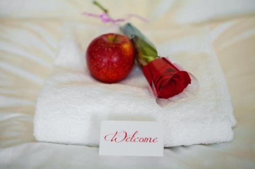 a red apple sitting on top of a towel with a note at Soluxe Hotel Almaty in Almaty