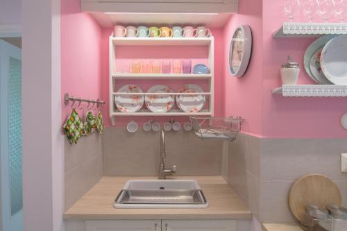cocina con fregadero y pared rosa en Lovely Apartment in Athens, en Atenas