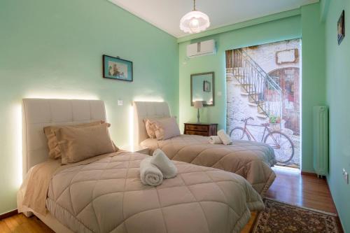 two beds in a room with green walls at Lovely Apartment in Athens in Athens