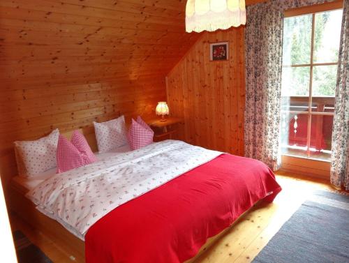 sypialnia z czerwono-białym łóżkiem w pokoju w obiekcie Glanzerhütte w mieście Innerkrems
