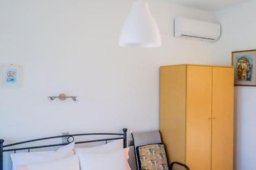 a bedroom with a bed and a yellow cabinet at Seaview Studio in Gázion