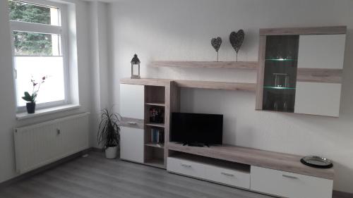 ein Wohnzimmer mit einem TV an der Wand in der Unterkunft NEW LOOK in Frankenberg