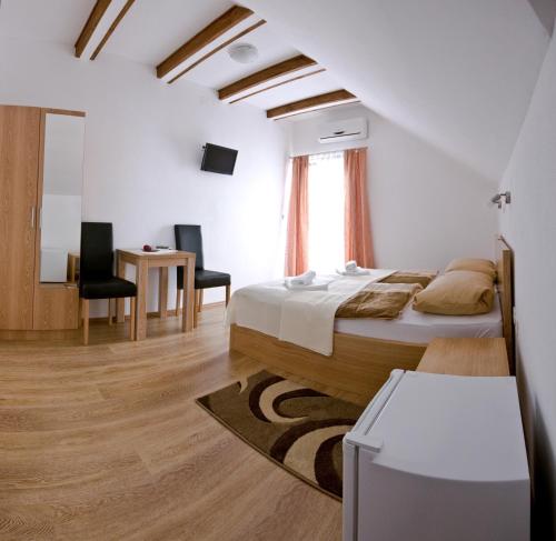 a bedroom with a bed and a table and chairs at Guest House Korita in Grabovac