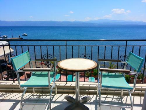 a table and chairs on a balcony with the ocean at Artemis Hotel in Amarinthos