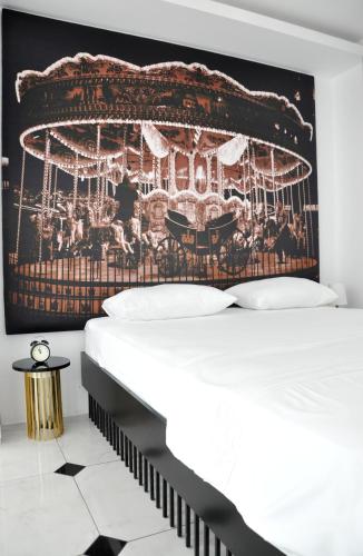 a bedroom with a bed and a poster of a carousel at Şato Design Hotel in Cesme
