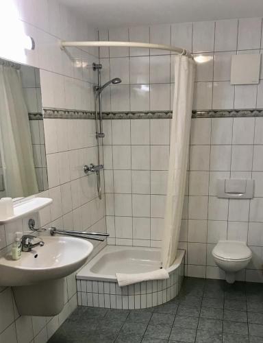 a bathroom with a tub and a sink and a toilet at "Bootsmannskammer" by Ferienhaus Strandgut in Born