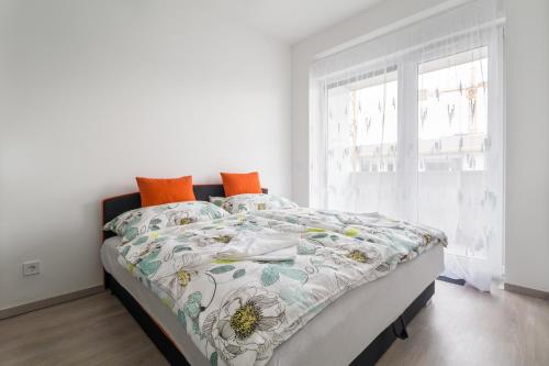 een witte slaapkamer met een bed met een dekbed en een raam bij BpR CHIC White Home with Terrace & A/C & Garage in Boedapest