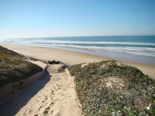ビスカロッスにある35 RÉSIDENCE LES COTTAGES 1 -036の砂浜と海の足跡がある海岸
