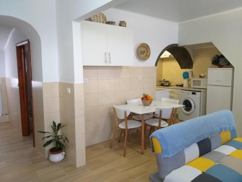a kitchen and living room with a table and a dining room at Casa da Rosarinha in Água de Alto