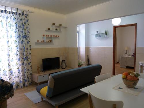 a living room with a couch and a table at Casa da Rosarinha in Água de Alto