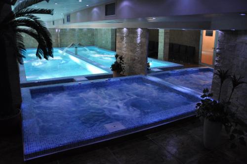a large swimming pool with a large blue tub at Premier Prezident Garni Hotel and Spa in Sremski Karlovci