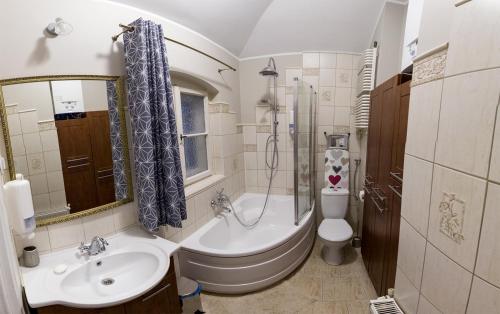 a bathroom with a tub and a toilet and a sink at Czarna Owca- Pokoje Gościnne in Gniezno