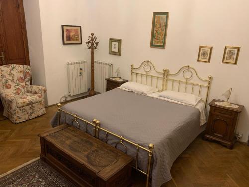 a bedroom with a bed and a chair at Villa Rosi in Cormòns