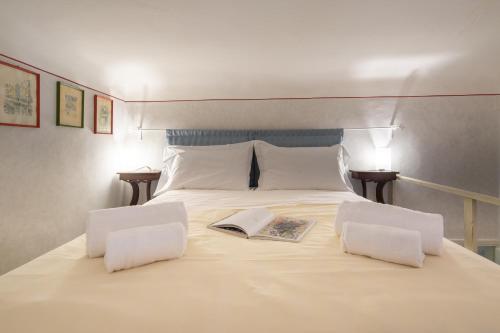 a bed with two white pillows and a book on it at Vellutini in Florence