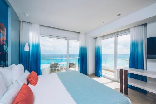 a bedroom with a large bed with a view of the ocean at Iberostar Selection Coral Cancun - Adults Only All Inclusive Resort in Cancún