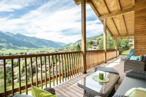 weranda ze stołem i krzesłami na balkonie w obiekcie alpin penthouse w mieście Piesendorf