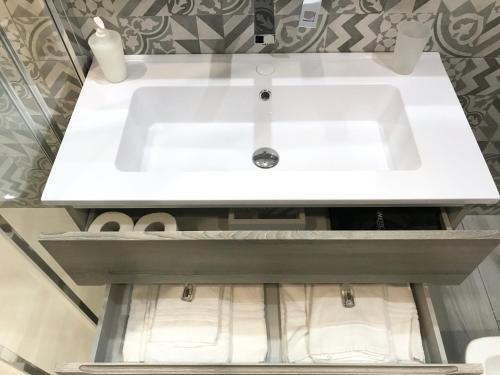a white sink in a bathroom with towels at BRAKKO 45 in Naples