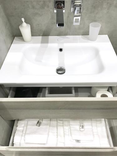 a white sink in a bathroom with a shelf at BRAKKO 45 in Naples
