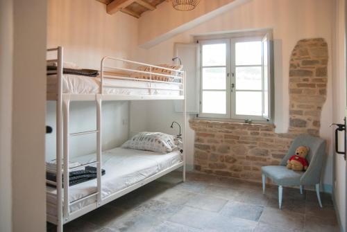 a bedroom with two bunk beds and a chair at Casale Biancopecora in SantʼElpidio Morico