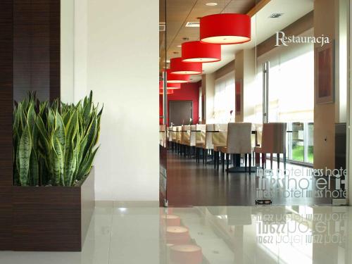 a conference room with a long table and a potted plant at Iness Hotel in Łódź