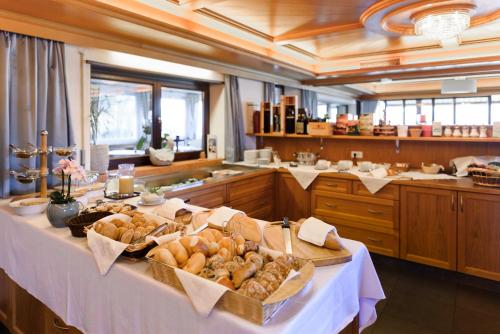 a table with bread and pastries on it in a kitchen at La Pergola PanoramaSuites in Tirolo